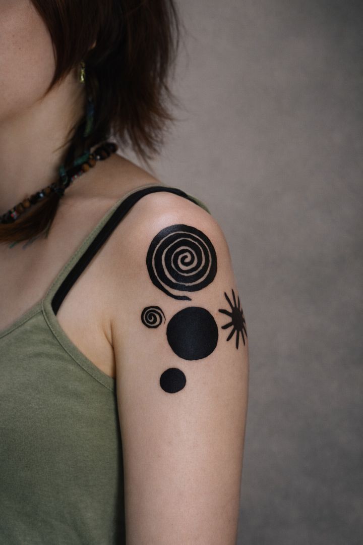 Abstract geometric blackwork tattoo on female shoulder