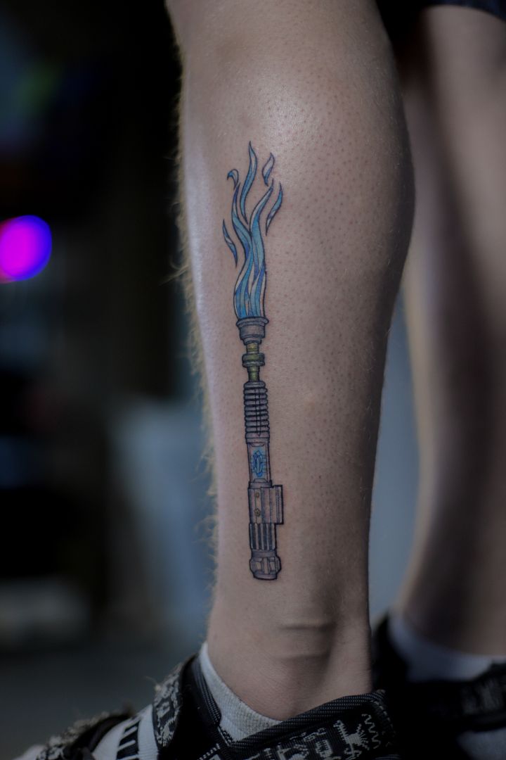 Color lightsaber tattoo on calf
