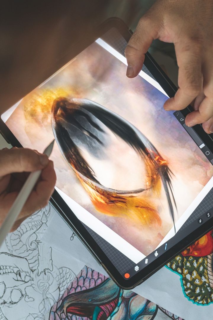 Tattoo artist creating a custom tattoo design on a digital tablet