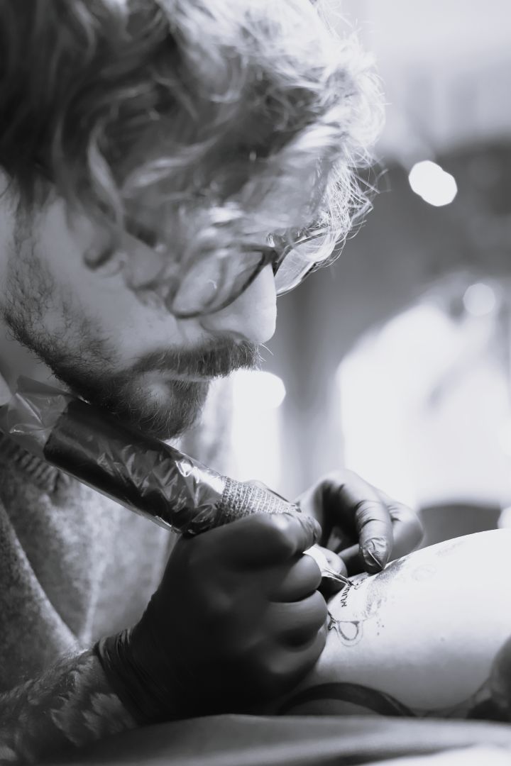 Tattoo artist Nikolay Ginzburg working on a client